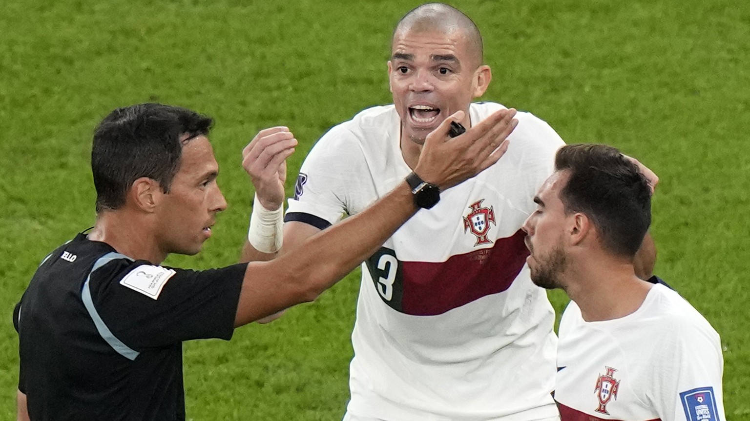 Referee Facundo Tello, left, discusses with Portugal&#039;s Pepe, center, and Portugal&#039;s Ricardo Horta during the World Cup quarterfinal soccer match between Morocco and Portugal, at Al Thumama S ...