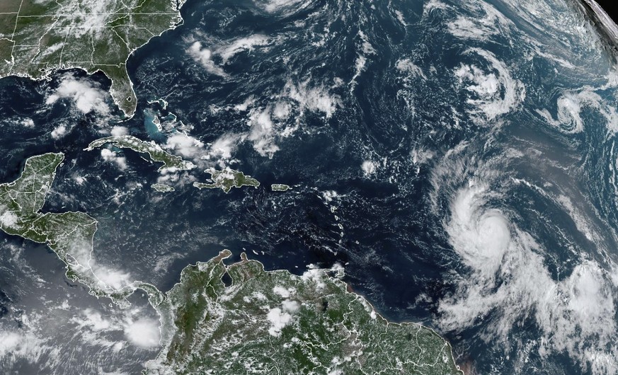 On Wednesday, September 6, 2023, a National Oceanic and Atmospheric Administration satellite image shows Hurricane Lee, right, in the central tropical Atlantic.  (NOAA over AP)