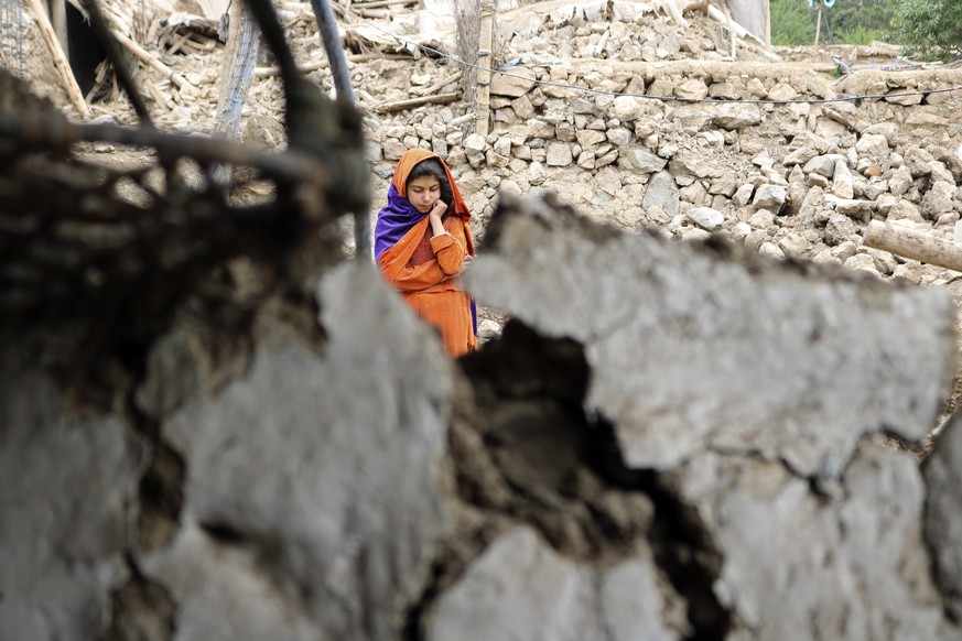 An Afghan girl stands near a house that was damaged by an earthquake in the Spera District of the southwestern part of Khost Province, Afghanistan, Wednesday, June 22, 2022. A powerful earthquake stru ...