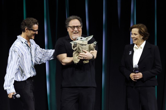 epa12038712 Actors Pedro Pascal (L) and Sigourney Weaver (R) react as film director Jon Favreau holds &#039;Grogu&#039; character during the Star Wars Celebration Japan in Chiba, near Tokyo, Japan, 18 ...