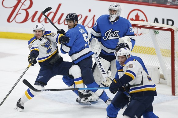 Winnipeg Jets&#039; Luca Sbisa (5) tries to clear St. Louis Blues&#039; Alexander Steen (20) from in front of goaltender Connor Hellebuyck (37) during the first period of an NHL hockey game Saturday,  ...