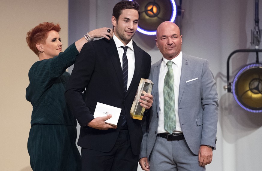 Simon Moser vom SC Bern, links, nimmt den Preis fuer den MVP Playoffs 2019 von Denis Vaucher, Direktor National League, rechts, entgegen, waehrend Moderatorin Steffi Buchli seinen Kragen richtet, bei  ...