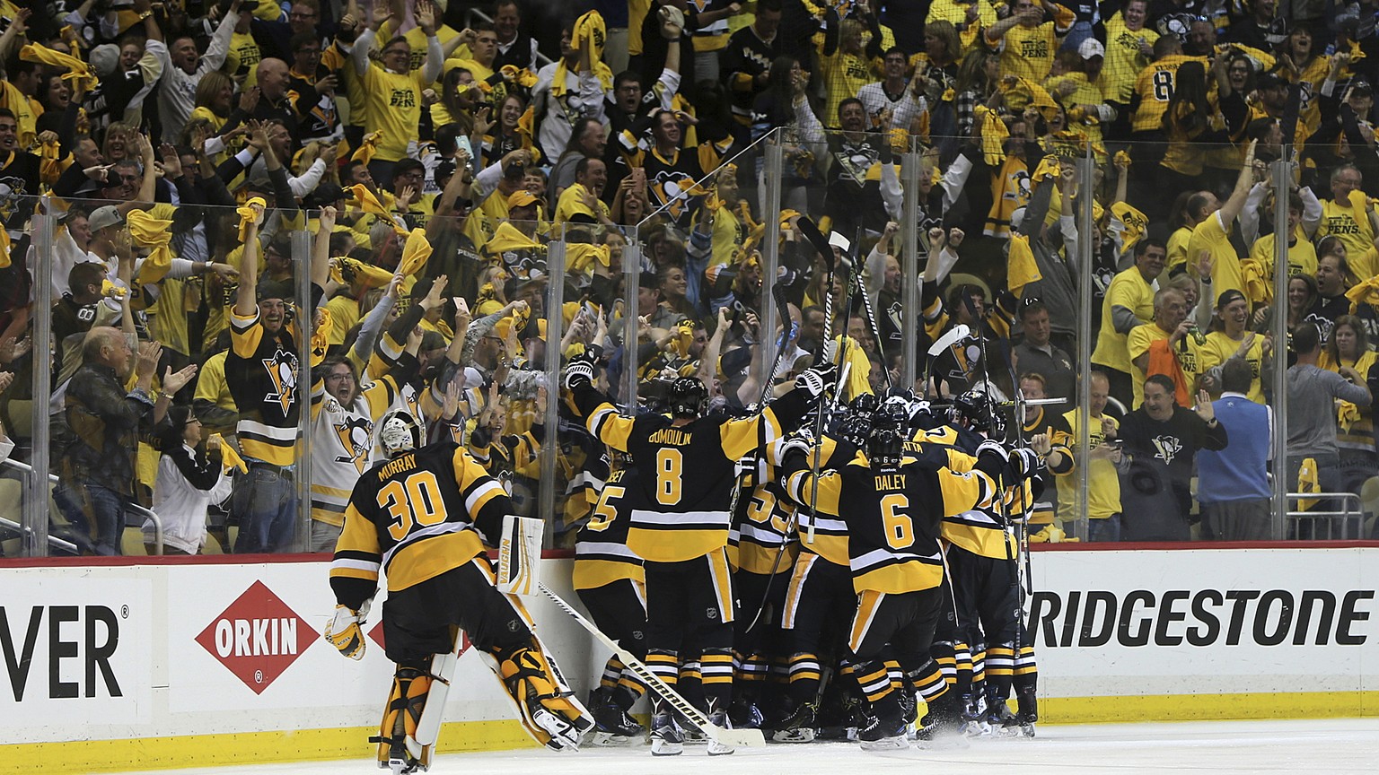 Pittsburgh Penguins players and fans celebrate as the Penguins&#039; Chris Kunitz scores a game winning goal during the second overtime period of Game 7 in the NHL hockey Stanley Cup Eastern Conferenc ...