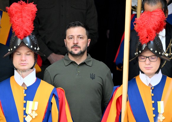 epa11654279 Ukrainian President Volodymyr Zelensky (C) is flanked by Swiss Guards as he leaves after a private audience with Pope Francis (not pictured) at the San Damaso courtyard in the Vatican City ...