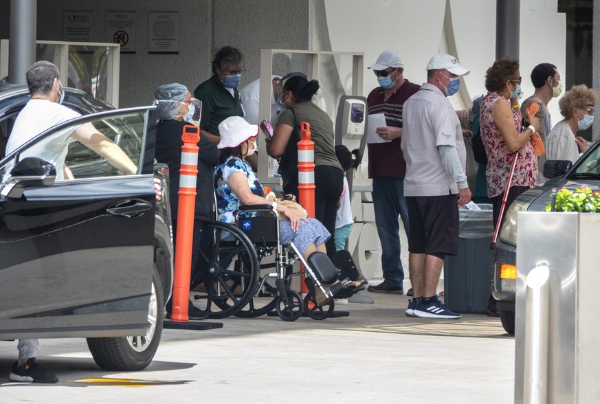 epa08509270 People wearing masks wait to enter the Jackson Memorial Hospital in Miami, Florida, USA, 25 June 2020. Florida&#039;s Department of Health confirmed a day earlier 5,508 additional cases of ...