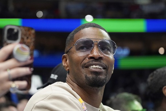 FILE - Jamie Foxx smiles during an NBA basketball game between the Washington Wizards and Dallas Mavericks in Dallas, Saturday, Nov. 27, 2021. Academy Award winning actor, Grammy winning singer and co ...