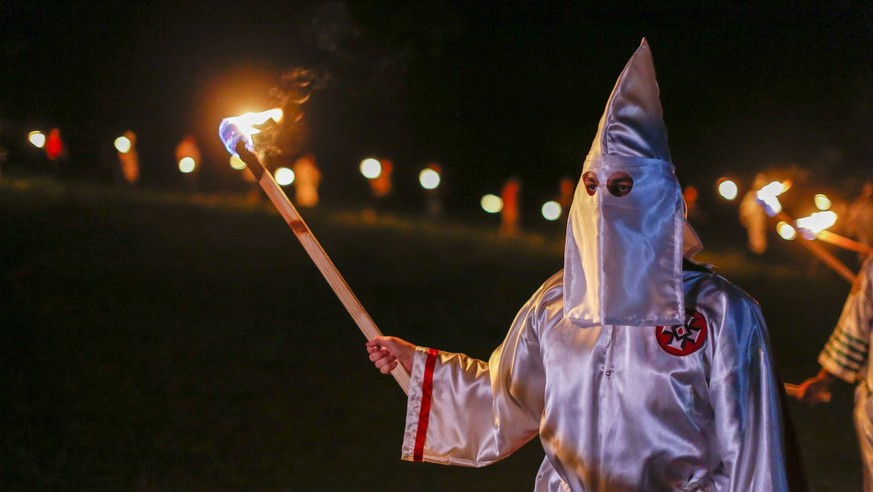 epa05275310 A picture made available on 24 April 2016 shows Pro-white rights organizations the neo-nazi National Socialist Movement and Ku Klux Klan groups participate in a cross and swastika burning  ...