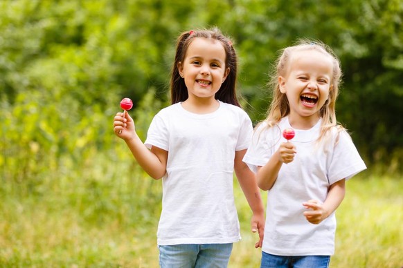 Schleckzeug ist super! Zwei Mädchet mit Lollypops.