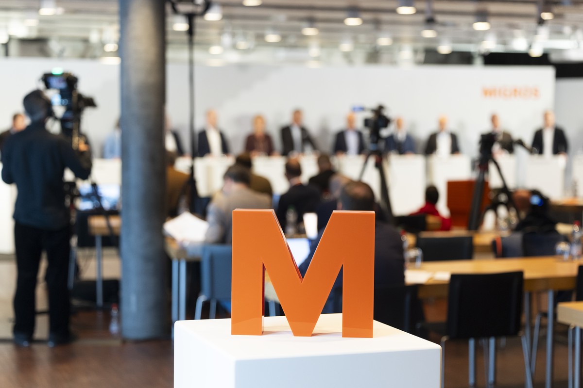 Ein Logo der Migros steht auf einem Podium waehrend einer Medienkonferenz der Migros, am Montag, 26. Oktober 2026 in Bern. Die Migros gibt bekannt, dass die 11 Migros Genossenschaften von einer Gruppe ...
