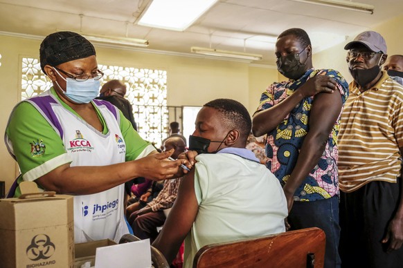 Ugandans receive Pfizer coronavirus vaccinations at the Kiswa Health Centre III in the Bugolobi neighborhood of Kampala, Uganda Tuesday, Feb. 8, 2022. Ugandan authorities are seeking to legally mandat ...