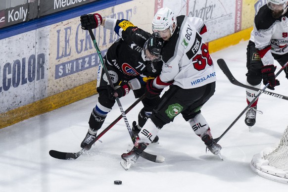 Fribourgs Killian Mottet, links, im Duell mit Lausannes Lukas Frick im Eishockey Qualifikationsspiel der National League zwischen dem HC Fribourg Gotteron und Lausanne HC, am Freitag, 5. Januar 2024,  ...