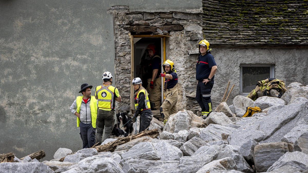 epa11432537 Rescue workers search the debris with a dog at the site of a landslide, caused by severe weather and heavy rain in the Misox valley, in Sorte village, Lostallo, southern Switzerland, 23 Ju ...