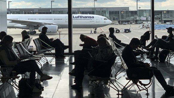 FILE -Passengers wait for their Lufthansa flight at the airport in Frankfurt, Germany, Saturday, May 15, 2021. The number of air passengers in Germany rebounded somewhat in 2021, but was still over tw ...