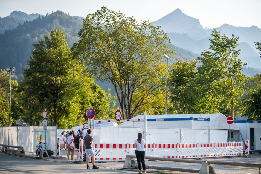 13.09.2020, Bayern, Garmisch-Partenkirchen: Personen steht in einer langen Schlange vor dem Corona Testzentrum der Stadt. Nach einem heftigen Corona-Ausbruch im oberbayerischen Garmisch-Partenkirchen  ...