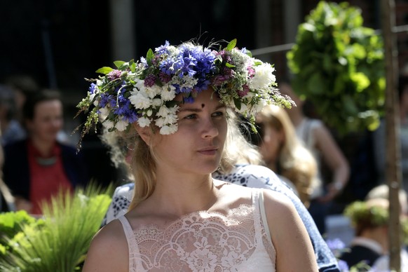 A woman wears chaplet of flowers and wild grass at &quot;Wild Grass Market&quot; before midsummer celebrations in Riga, Latvia, June 22, 2016. REUTERS/Ints Kalnins