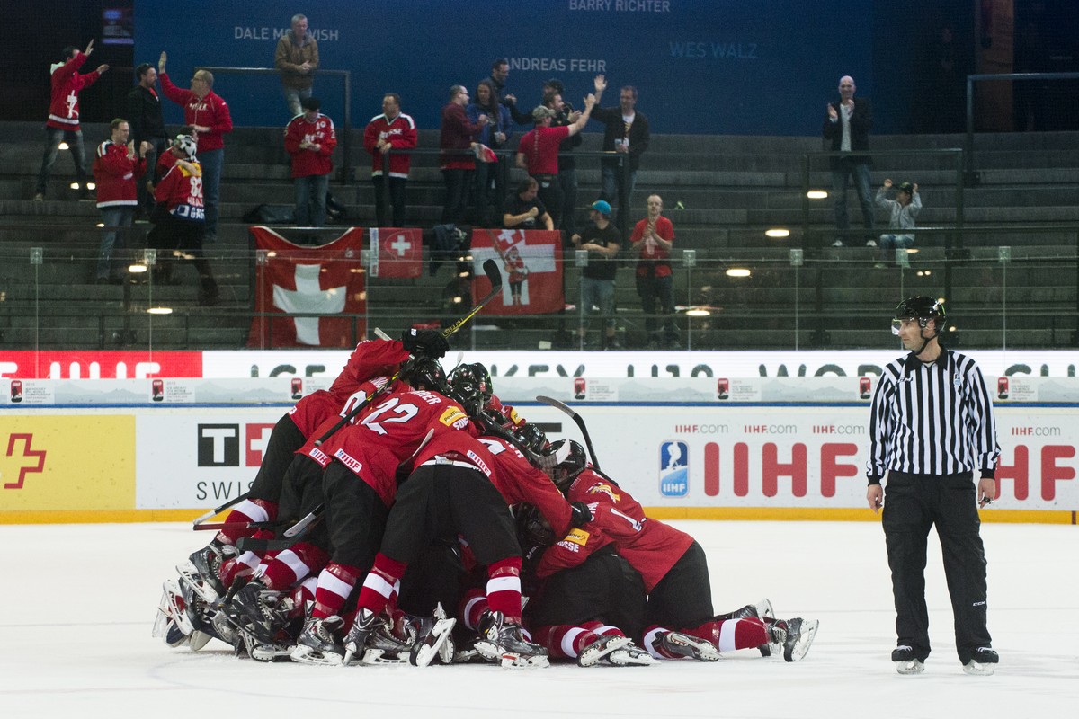 Denis Malgin wird nach seinem Overtime-Tor von den Teamkameraden «gehügelt».