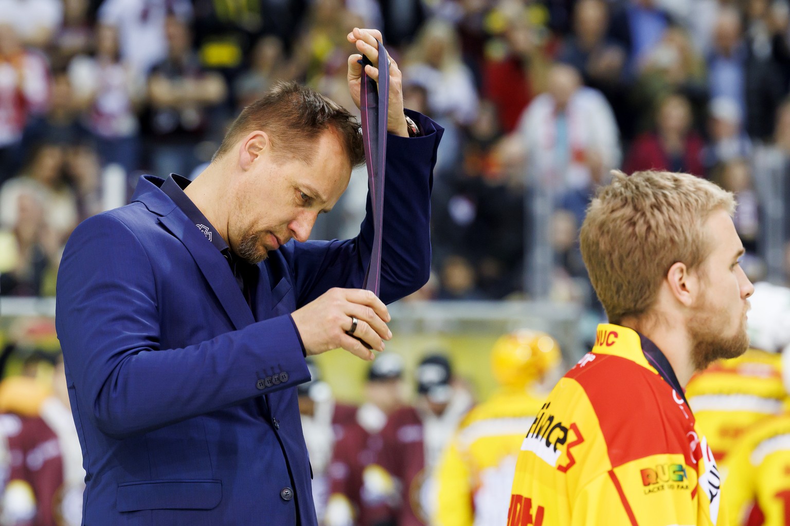 Biel&#039;s Head coach Antti Toermaenen removes the medal after losing the seventh and final leg of the ice hockey National League Swiss Championship final playoff game between Geneve-Servette HC and  ...