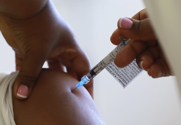 FILE - In this Feb. 17, 2021, file photo, a health care worker receives a Johnson &amp; Johnson vaccine at a hospital in Khayelitsha, Cape Town, South Africa. South Africa has suspended giving the Joh ...