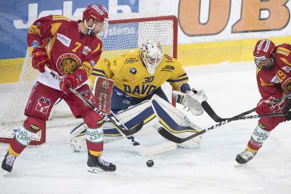Tigers Emanuel Peter, links und Pascal Berger, rechts, kaempfen um den Puck gegen Davos Goalie Joren van Pottelberghe, Mitte, waehrend dem Meisterschaftsspiel der National League zwischen den SCL Tige ...