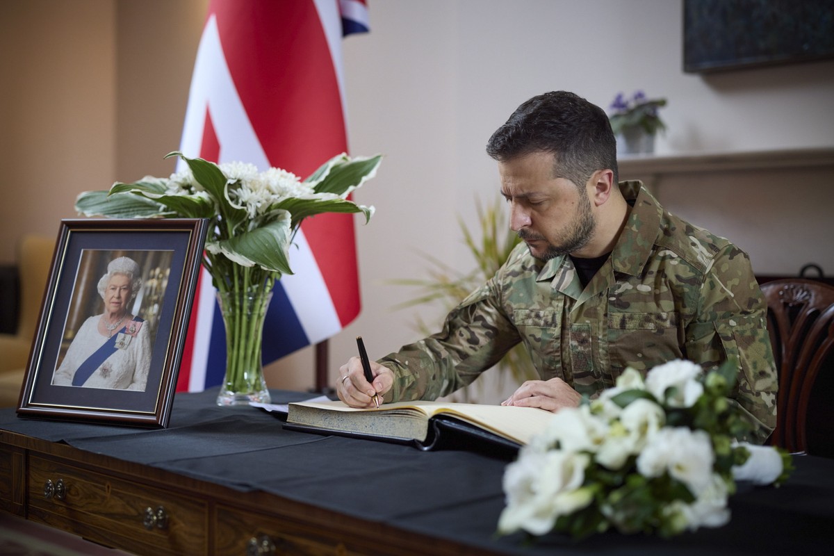 epa10179451 A handout photo made available by the Ukrainian Presidential Press Service shows Ukrainian President Volodymyr Zelensky honoring the memory of Britain's Queen Elizabeth II during his  ...