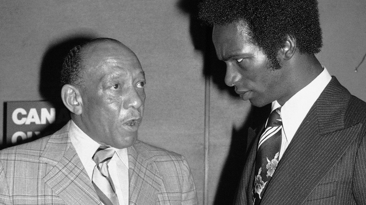 Olympic gold medallists Jesse Owens, left, and Bob Beamon exchange views as they meet at a breakfast in New York on May 25, 1976. Owens, who won his medal for the so-called "Nazi Games"; is  ...