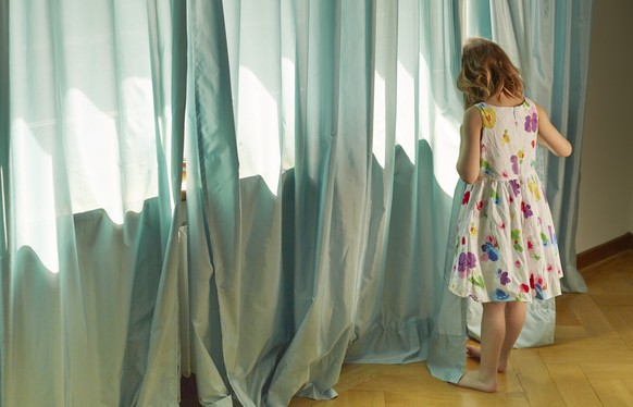 ARCHIVBILD ZUM ENTSCHEID DER RECHTSKOMMISSION DES STAENDERATES ZUR UMSETZUNG DER PAEDOPHILEN-INITIATIVE -- [ Symbolic Image, Posed Picture, ] - Girl standing on a window, hiding her face with a curtai ...