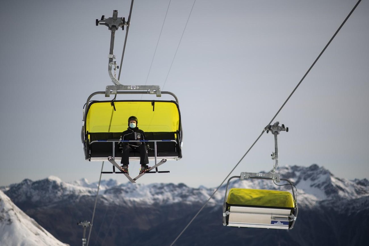 Ein Skifahrer mit Schutzmaske sitzt auf einem Sessellift, aufgenommen zum Start der Skisaison, am Sonntag, 25. Oktober 2020, auf Parsenn in Davos. Das Skigebiet Davos Klosters startet den Wochenendbet ...