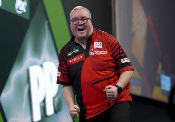 Stephen Bunting celebrates winning his match against Madars Razma on day ten of the Paddy Power World Darts Championship at Alexandra Palace, London, Friday, Dec. 27, 2024. (Bradley Collyer/PA via AP)