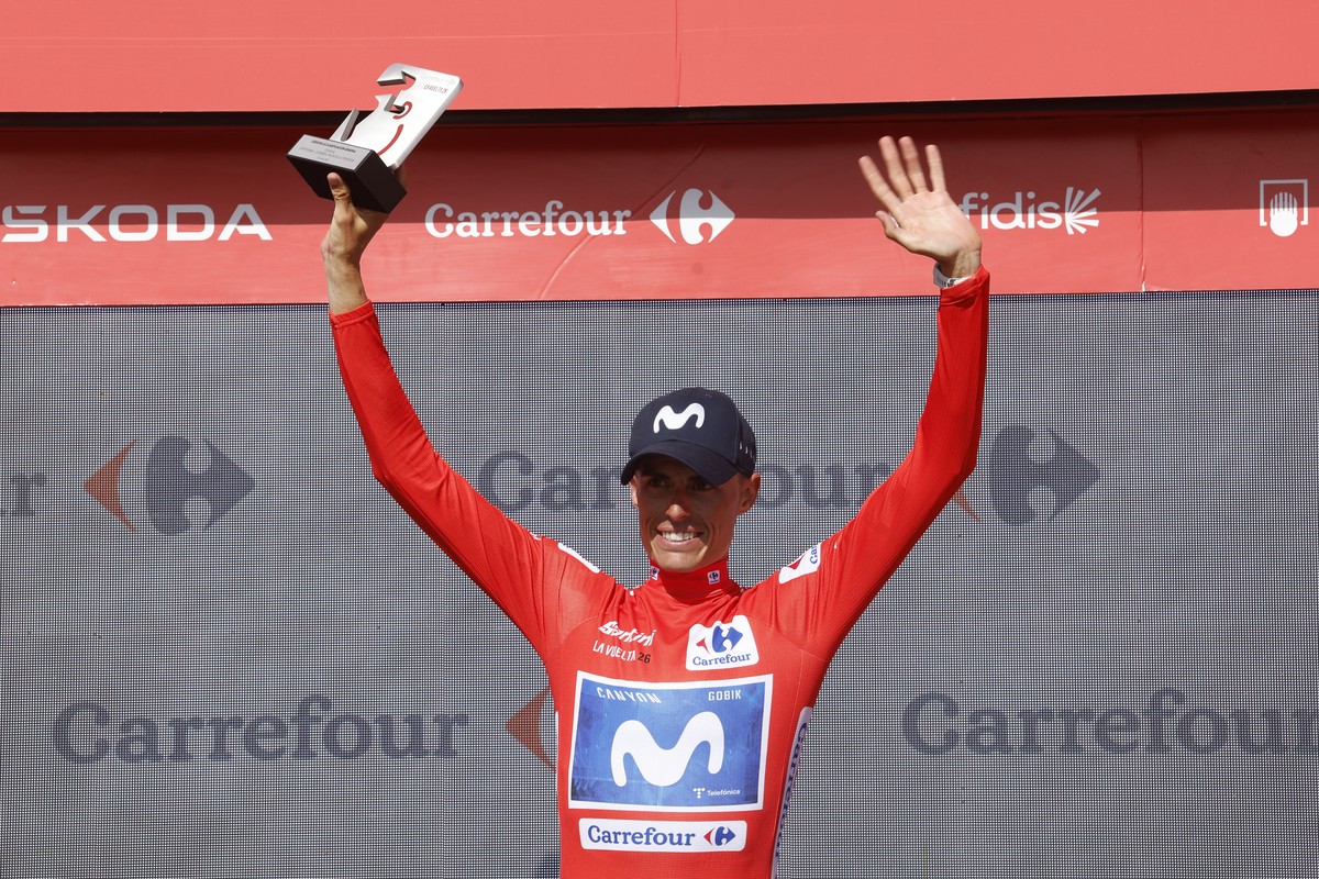 epa13222702 Spanish cyclist Enric Mas of Movistar wears the red overall leader's jersey on the podium following the wears the red overall leader's jersey on the podium following the Stage 16 ...