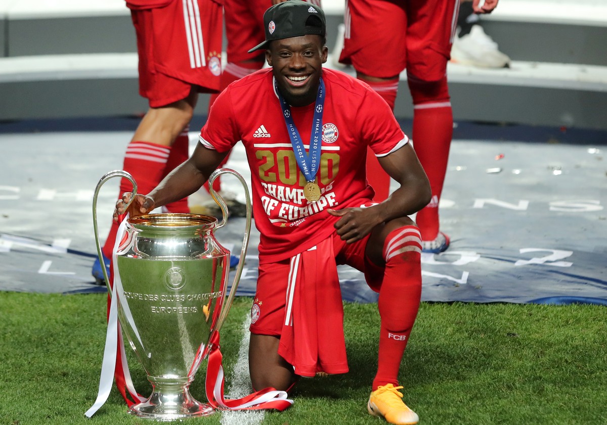 epa08621130 Alphonso Davies of FC Bayern celebrates with the trophy after winning the UEFA Champions League final between Paris Saint-Germain and Bayern Munich in Lisbon, Portugal, 23 August 2020. EPA ...