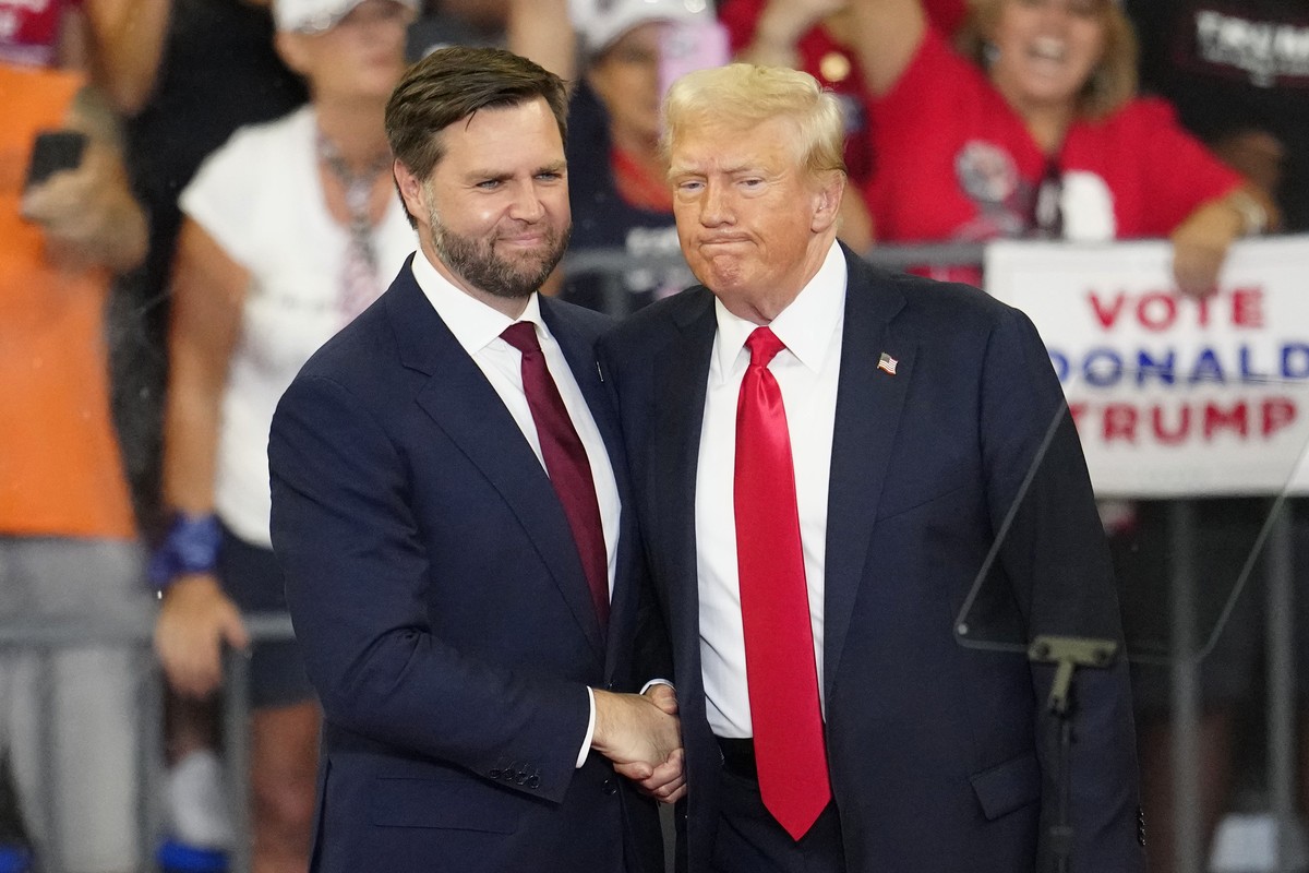 Republican vice presidential candidate Sen. JD Vance, R-Ohio, left, and Republican presidential candidate former President Donald Trump, shake hands at a campaign rally at Georgia State University in  ...