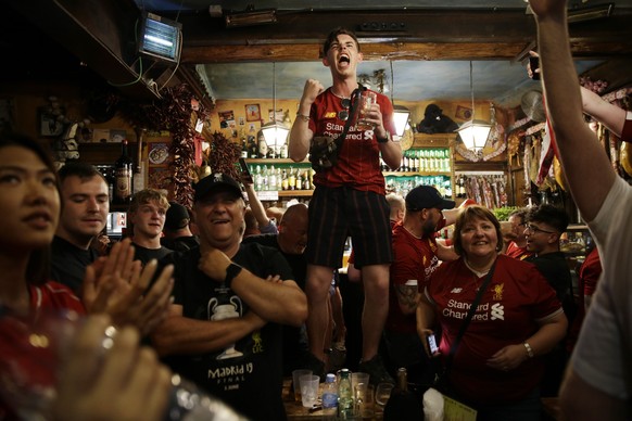 Liverpool supporters celebrate the victory in a pub at the final whistle of the Champions League final soccer match between Tottenham Hotspur and Liverpool at the Wanda Metropolitano Stadium in Madrid ...