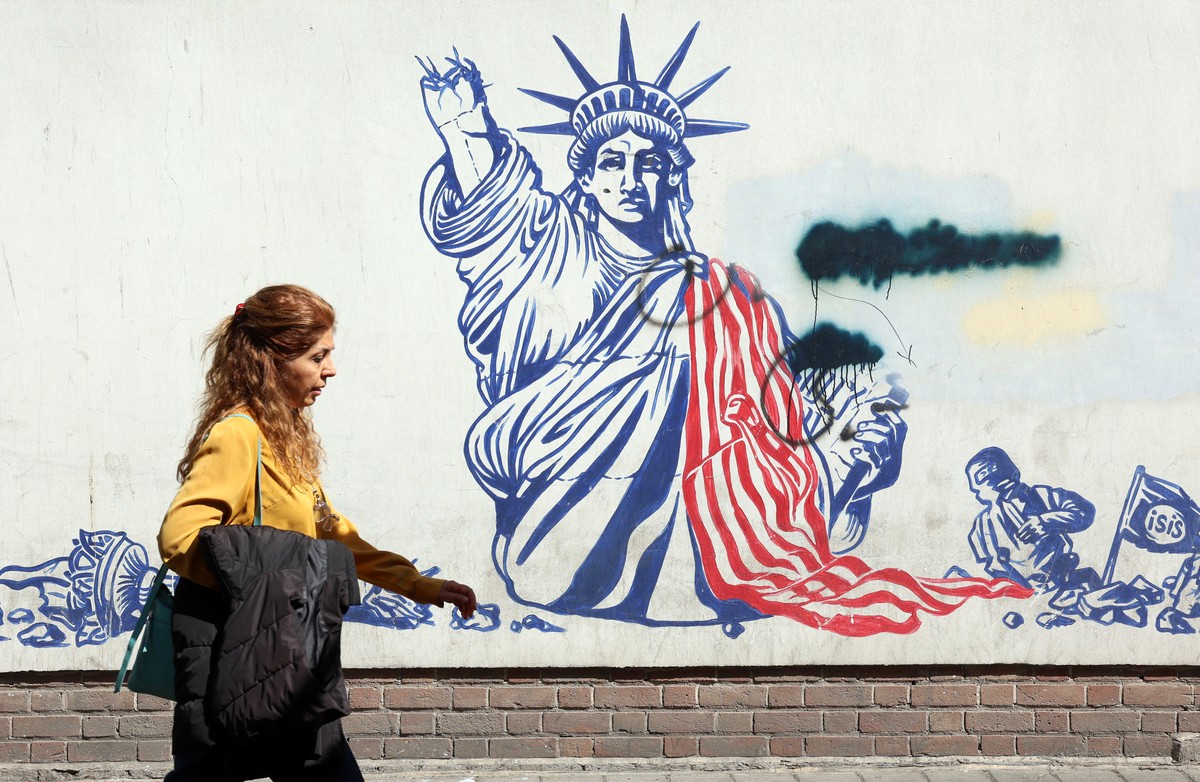 epa12882108 An Iranian woman walks next to an anti-US mural near the former US Embassy in Tehran, Iran, 11 April 2026. Iran and the US are expected to hold negotiations in Islamabad, Pakistan, followi ...