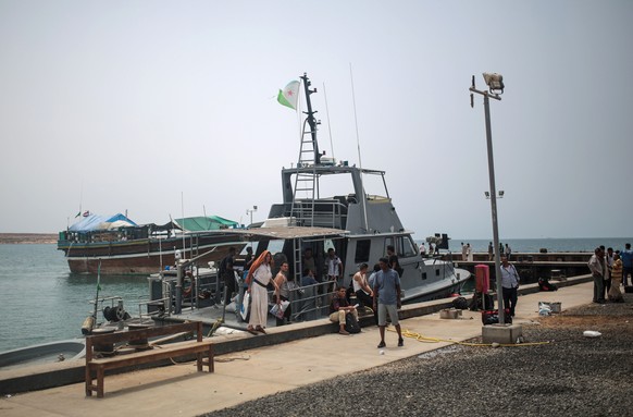 In this Tuesday, May 19, 2015 photo, newly-arrived Yemeni refugees wait at the Obock port in northern Djibouti. Many of the refugees arrived with just the few belongings they could carry, mostly on sm ...