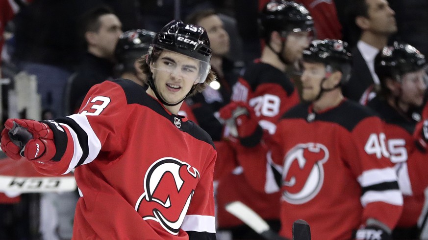 New Jersey Devils center Nico Hischier, of Switzerland, gestures toward teammate goalie Keith Kinkaid, not pictured, after scoring a goal on the Tampa Bay Lightning during the first period of an NHL h ...