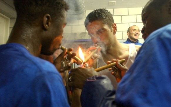 Die Spieler des FC Basel Yao Aziawonou, links, Pascal Zuberbuehler, Mitte, und Herve Tum, rechts, und Massimo Ceccaroni (hinten) feiern in der Kabine feucht-froehlich und mit Zigarren, nach ihrem 3:0- ...