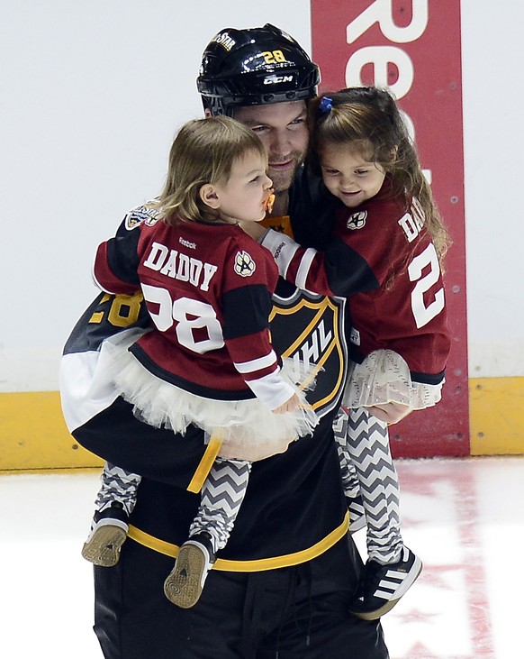 FILE - In this Jan. 31, 2016, file photo, Pacific Division forward John Scott carries his children onto the ice after being named most valuable player in the NHL hockey All-Star championship game, in  ...