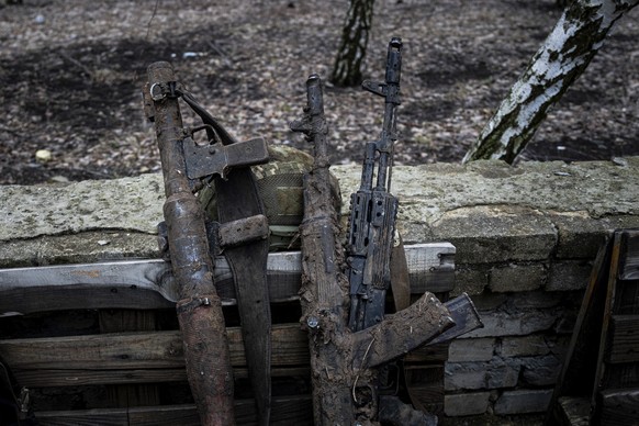 Mud-stained guns of Ukrainian soldiers are seen on the street of Chasiv Yar, Ukraine, Wednesday, March 8, 2023. (AP Photo/Evgeniy Maloletka)