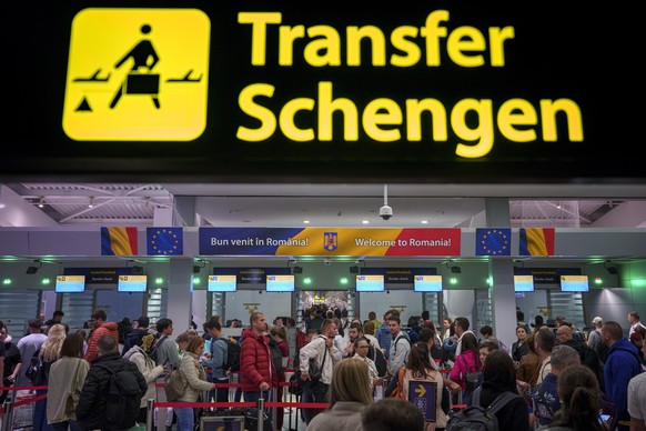 Passengers arriving at the Henri Coanda International Airport pass under a Schengen Information sign, in Otopeni, near Bucharest, Romania, Sunday, March 31, 2024. Romania and Bulgaria joined Europe&#0 ...