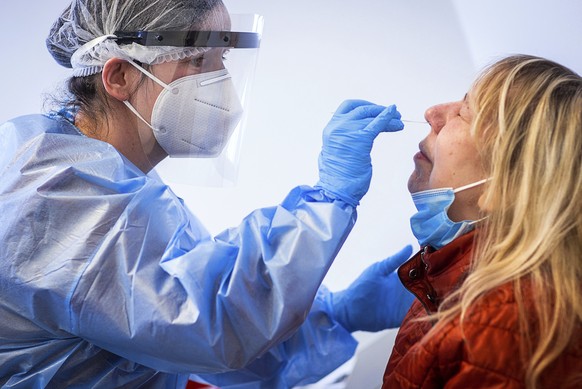 Susann Zierenner, left, of the German Red Cross takes a test with a test stick from resident Angelika Dankert after the opening of the municipal Corona test centre in Ludwigslust, Germany, Monday, Mar ...