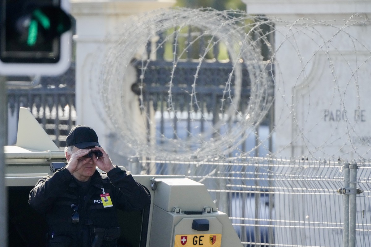A police officer looks through a binoculars to guard the area in front of the 'Villa la Grange' ahead of the meeting of US President Joe Biden and Russian President Vladimir Putin at the vil ...