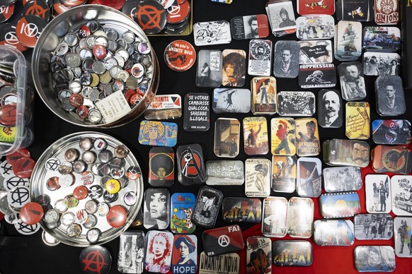 Buttons and magnets lie on a seller's table during the Anarchy 2023 international anti-authoritarian meeting in Switzerland, St-Imier, on Wednesday, July 19, 2023. The meeting will take place from ...