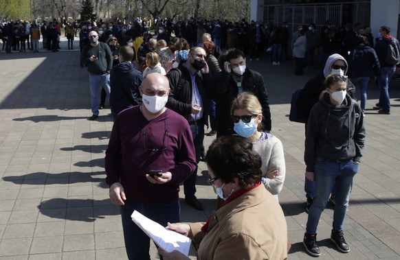 epa09100967 People wait in line in front of the Belgrade Fair vaccination center in Belgrade, Serbia, 27 March 2021. Thousands of vaccine-seekers from neighboring countries like Bosnia and Herzegovina ...