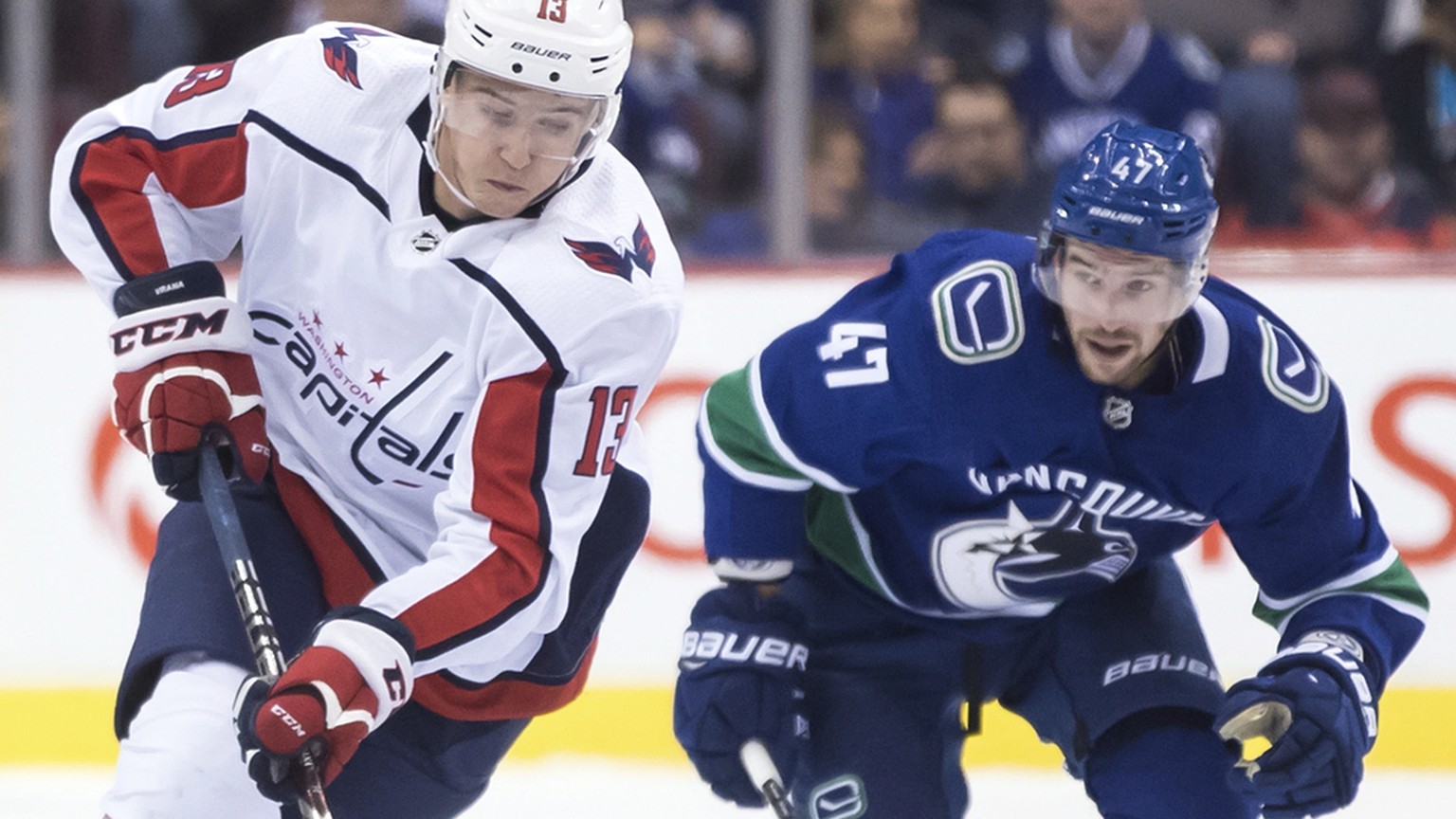 Washington Capitals&#039; Jakub Vrana, front left, of the Czech Republic, skates with the puck while being watched by Vancouver Canucks&#039; Sven Baertschi, of Switzerland, during the first period of ...