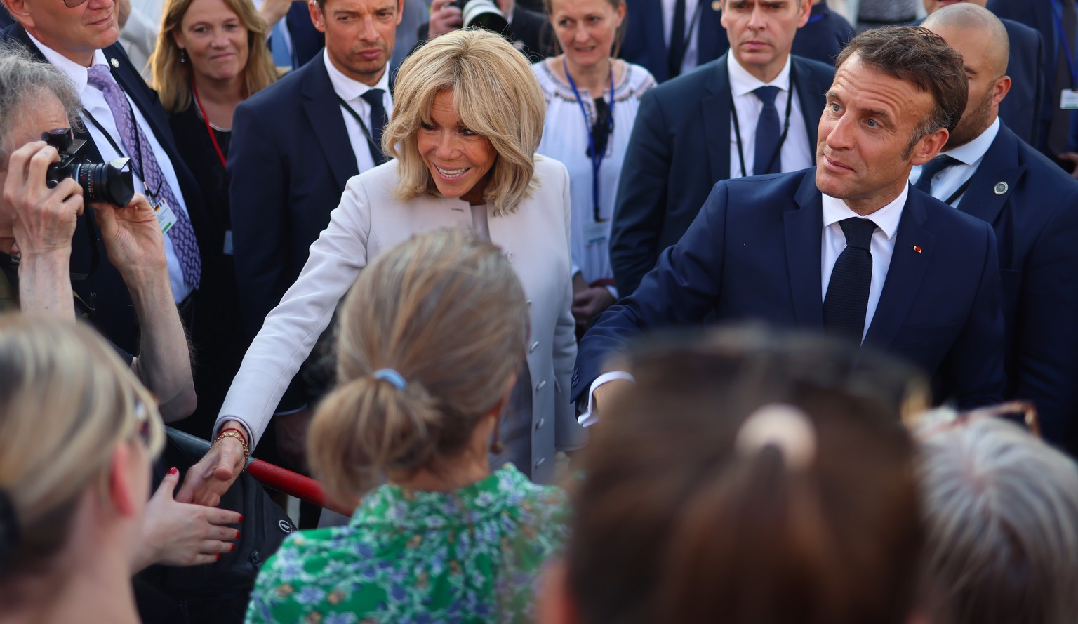 epa11372096 French President Emmanuel Macron and his wife Brigitte Macron shake hands with people as they visit the Brandenburg Gate in Berlin, Germany, 26 May 2024. Macron visits Germany from 26 to 2 ...