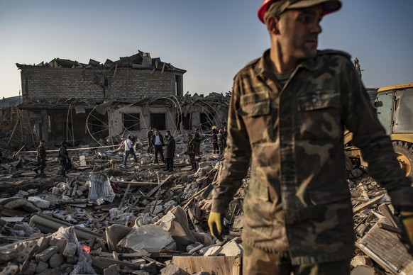 Azerbaijani soldiers and firefighters look for survivors from destroyed houses in a residential area in Ganja, Azerbaijan&#039;s second largest city, near the border with Armenia, after rocket fire ov ...