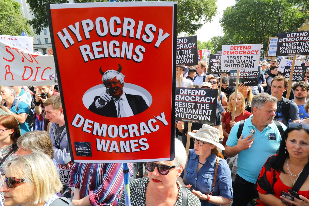 epa07806913 Anti Brexit protesters with a banner 'Hypcrisy Reigns, Democracy Wanes' outside Downing Street in Whitehall during a protest against Brexit and the prorogation of parliament in L ...