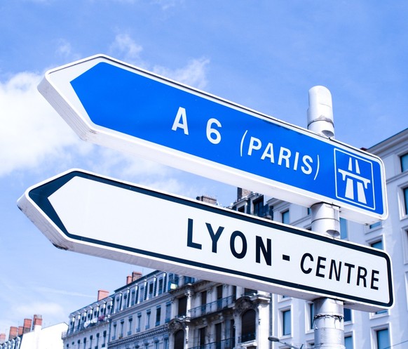 Ein Strassenschild/Wegweiser, welches den Weg nach Paris (Frankreich) und Lyon anzeigt.