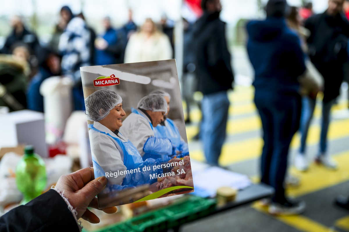 Une employée de Micarna, filiale du groupe Migros, montre le règlement du personnel lors d'une journée de grève.