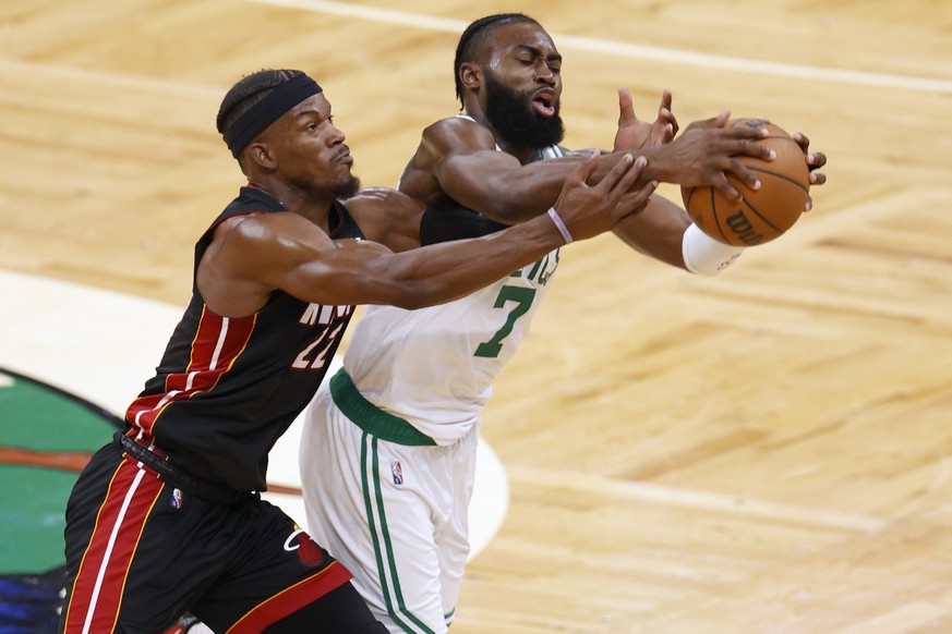 epa09970706 Boston Celtics guard Jaylen Brown (R), and Miami Heat forward Jimmy Butler (L) reach for a loose ball, during the first half of Game 4 of the NBA Eastern Conference Finals between the Bost ...